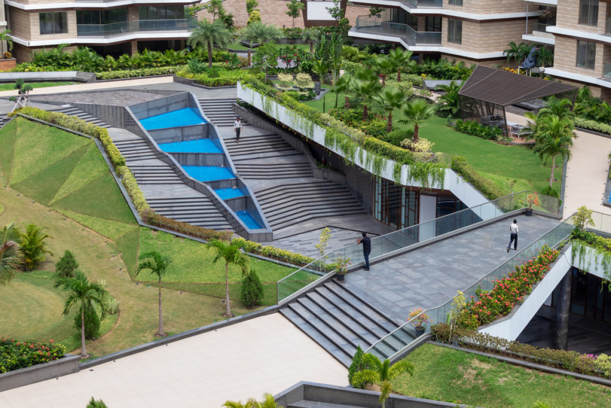 Angular grass mounts lift up in the centre of the landscaped space revealing a sub terranean club