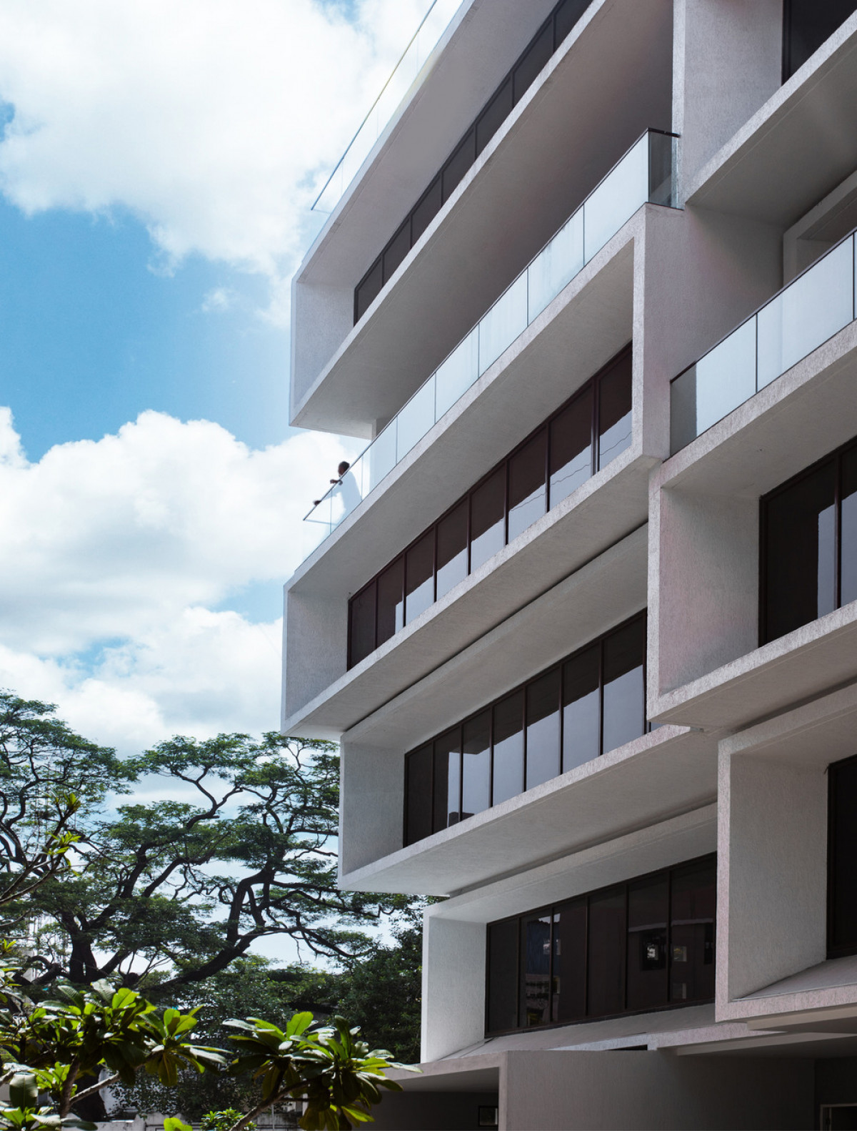 The ground level plinth is small to facilitate circulation with office floors cantilevering out above.  Photo credit: BRS Sreenag, Sreenag Pictures