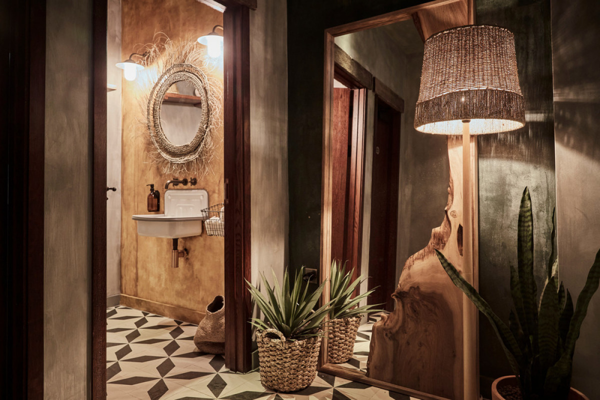 Restrooms with concrete tiles, bespoke live edge mirror and utilitarian sinks | Photo credit: Charlie Mckay