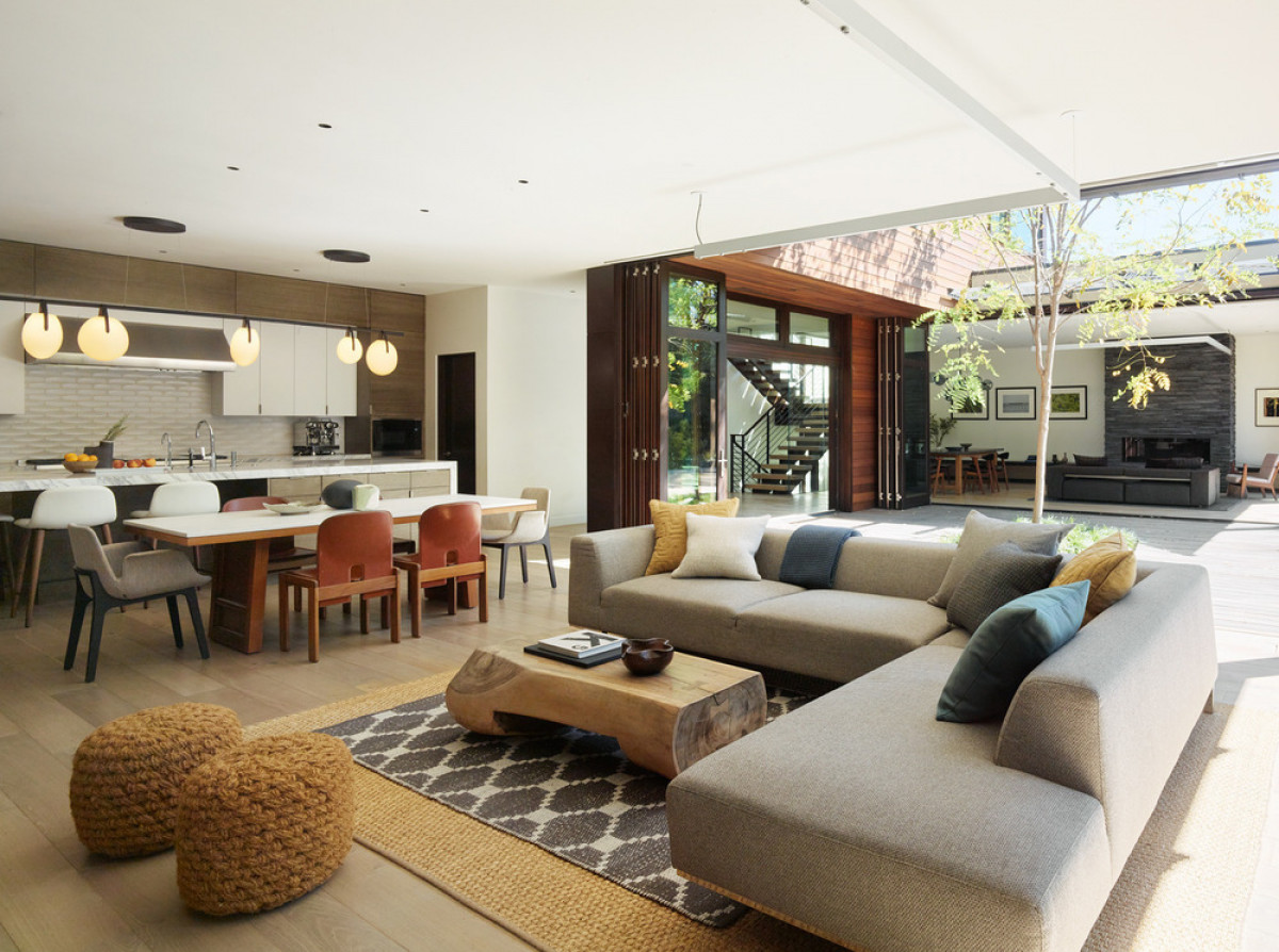   Butterfly House: The generously-sized family room (foreground) and living room (background) feature accordion glass walls that fully open to the courtyard and an expansive garden. Photo credit: Matthew Millman 