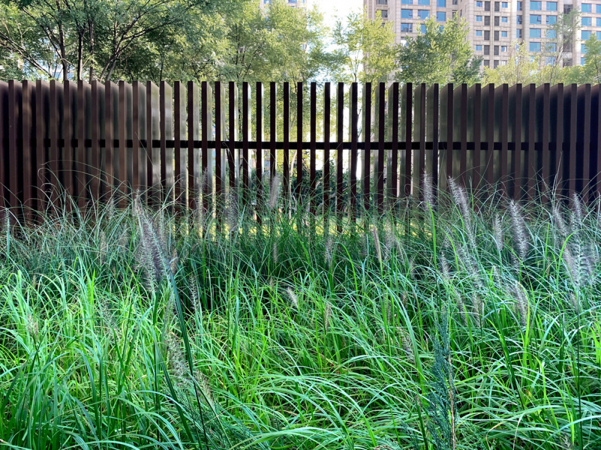 The slatted construction fence allows for views to the landscape beyond. | Photo credit: WU Qingshan