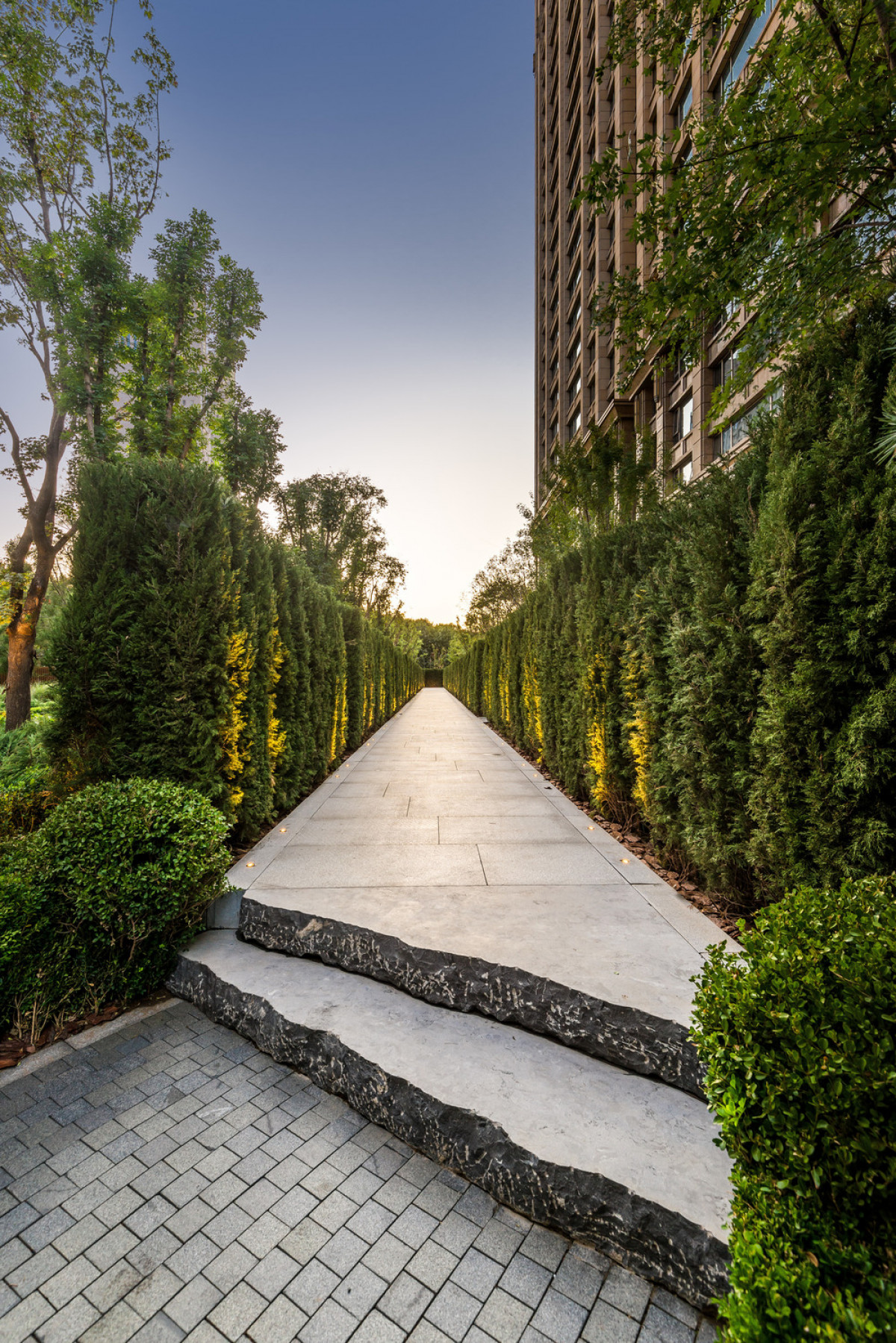 Hand chipped stone slabs create a skewed entry to the residence lobby gardens, ‘natural’ counterpoint to the more architecturally organized entry sequence. | Photo credit: Amey Kandalgaonkar