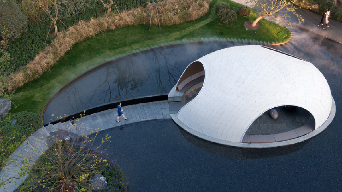 Visitors descend along a sunken path beneath the water's surface, leading to the Thin-shell Metal Woven Pavilion, where a serene and immersive experience awaits. Photo credit: Photo by Fancy Images